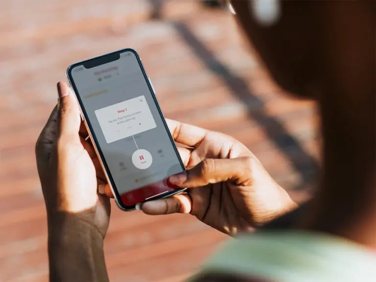 A person holds a phone while using the SaySomethingin app.