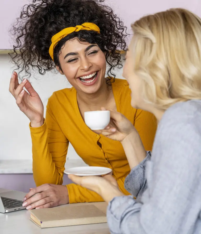 Two women laughing and having a cup of tea