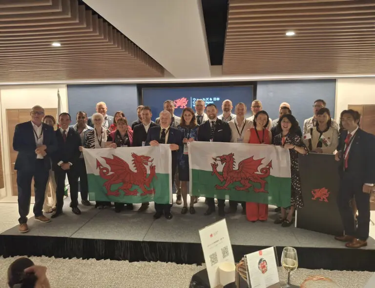 Attendees from Japan and Wales stand for photographs with the Welsh flag at Welsh Government Economy Trade Mission in Tokyo, including Nick from SSi.