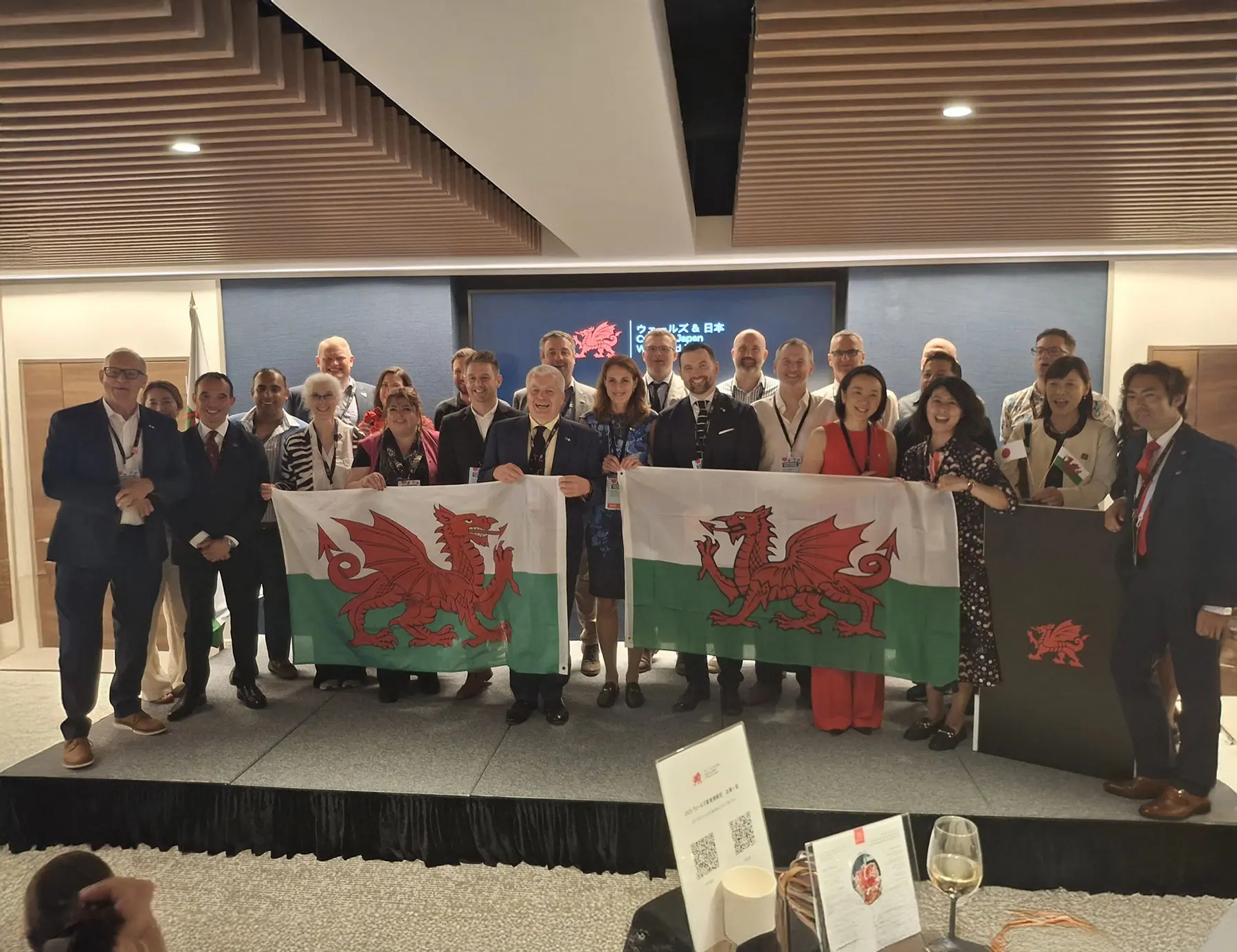 Attendees from Japan and Wales stand for photographs with the Welsh flag at Welsh Government Economy Trade Mission in Tokyo, including Nick from SSi.
